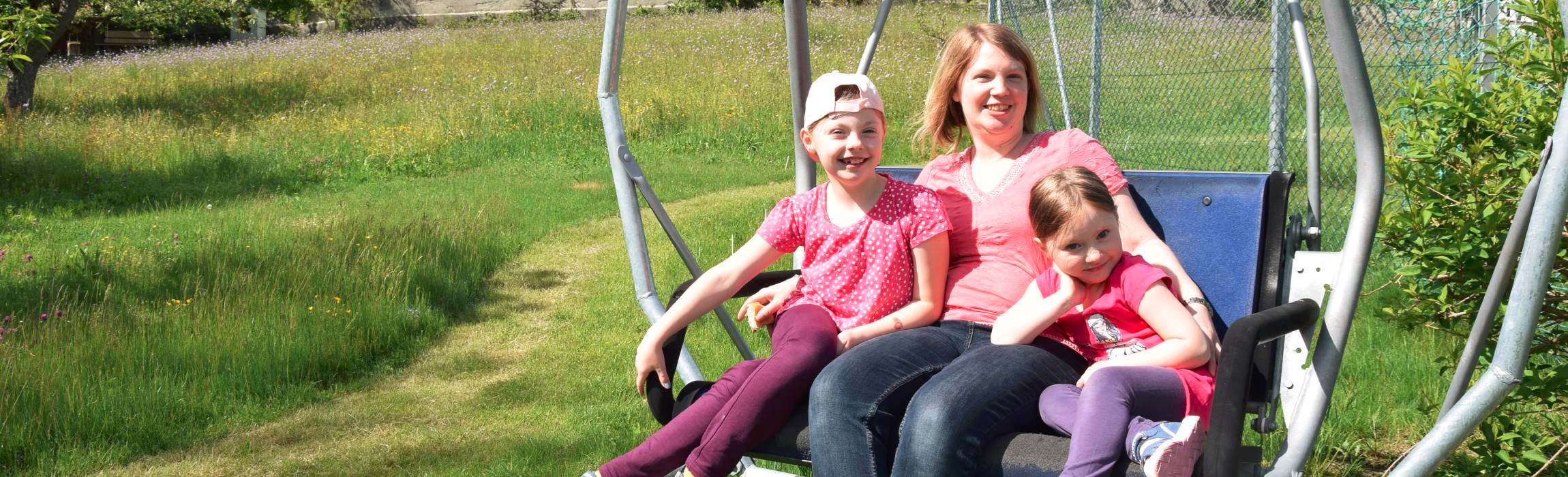 Mutter mit Kinder auf Schaukel